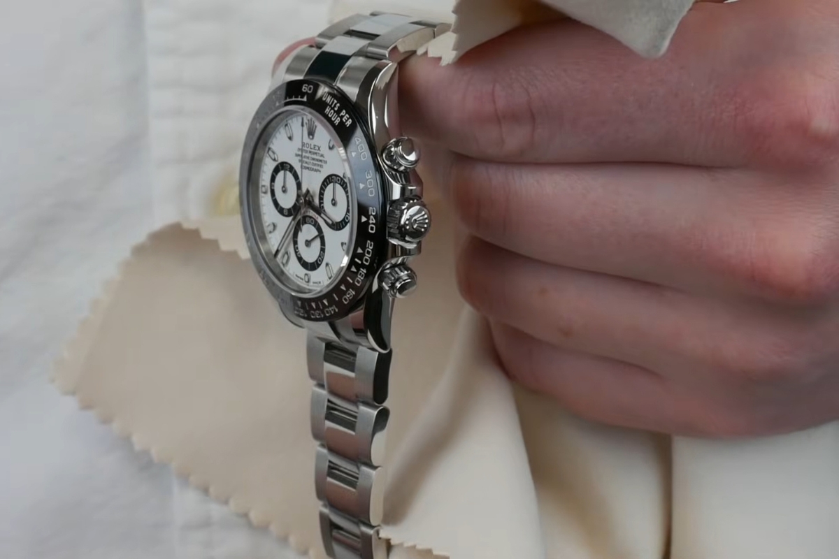 osoba čisti rolex sat sa krpicom